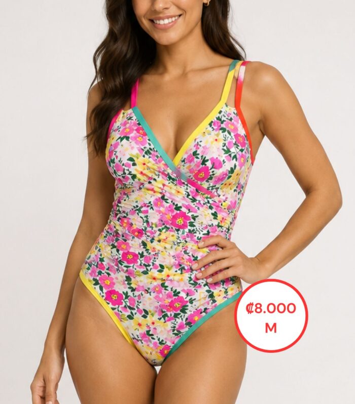 Modelo mujer usando vestido de baño enterizo floral multicolor con escote cruzado y tirantes de colores.